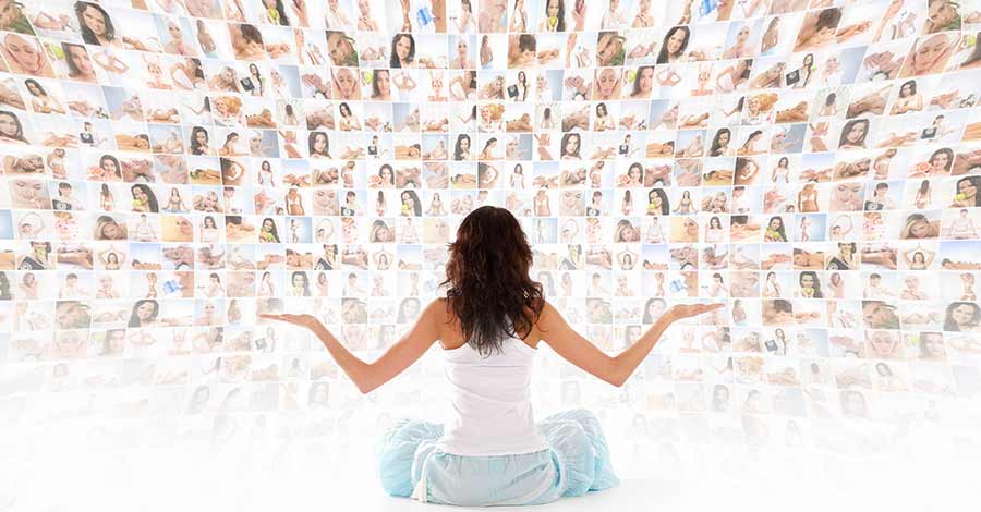 Mulher sentada de costas observando uma parede repleta de fotos digitais exibidas em tela curva