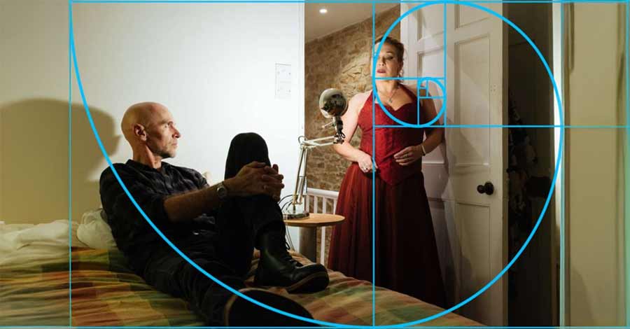 Composição fotográfica mostrando um homem sentado e uma mulher em pé em um quarto, com a espiral de Fibonacci sobreposta para ilustrar proporção áurea.